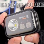 A close-up of the Brinyte HC01 headlamp showing the white and red auxiliary lights and buttons.